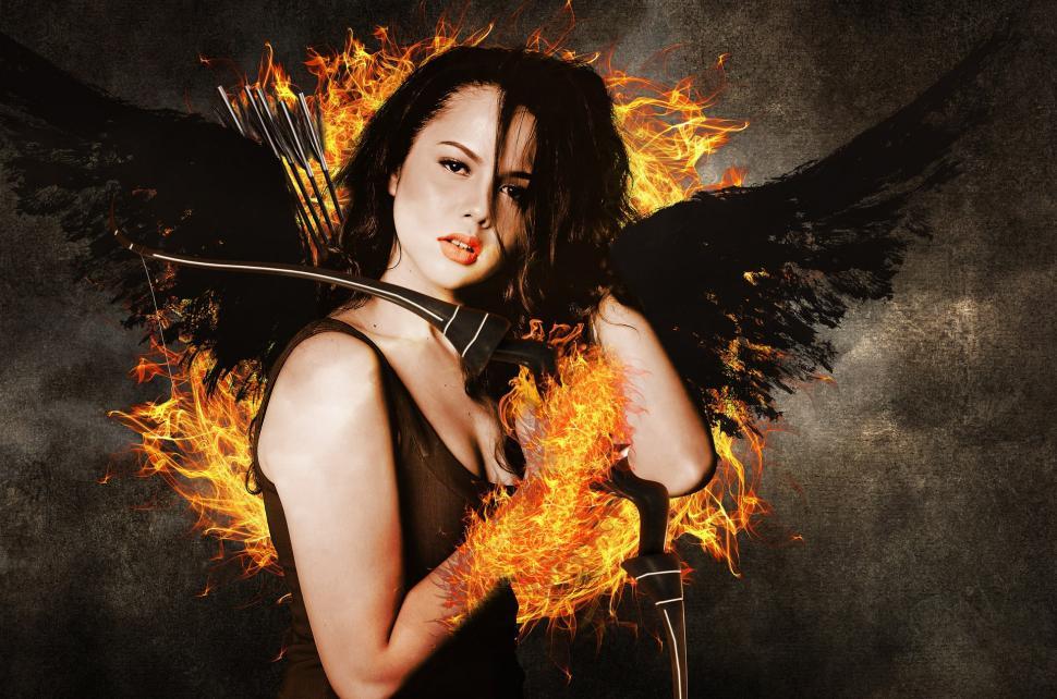 Free Image of Woman Holding Bow and Arrow in Front of Fire 