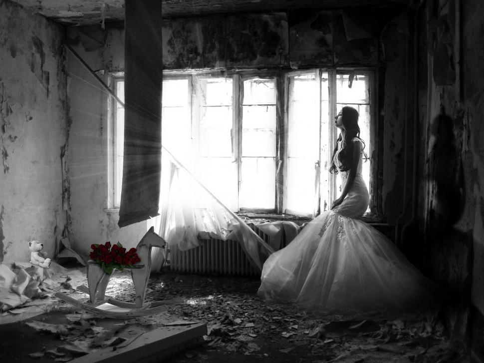 Free Image of Woman in Wedding Dress Standing in Run Down Room 