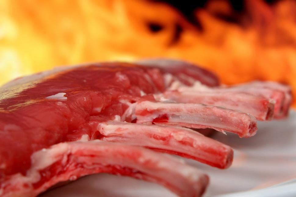 Free Image of Close Up of Meat on Plate With Fire in Background 