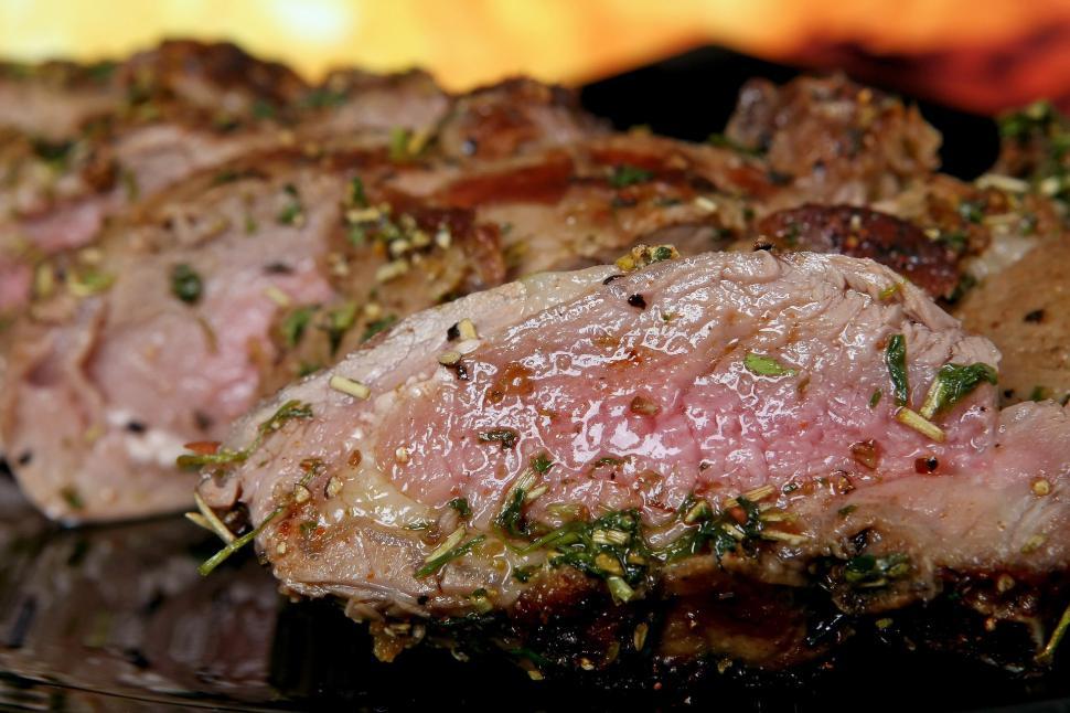 Free Image of Close Up of Meat on Plate With Fire in Background 