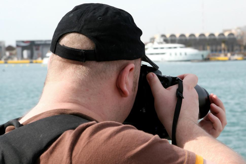 Free Image of Man Taking Picture of Boat in Water 