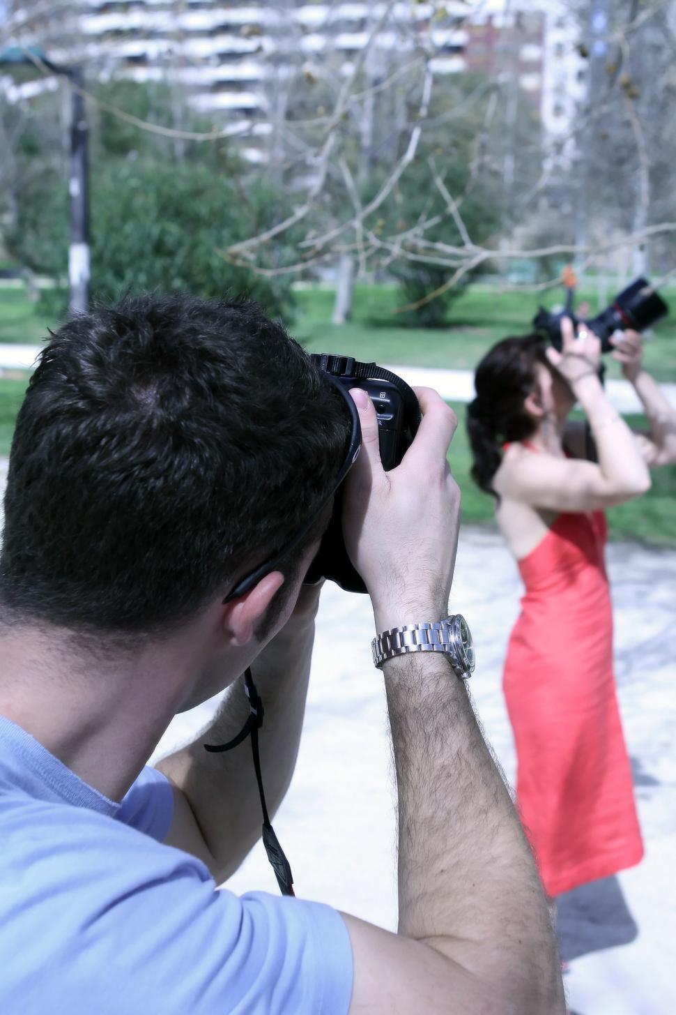 Free Image of A Man Taking a Picture of a Woman in a Red Dress 