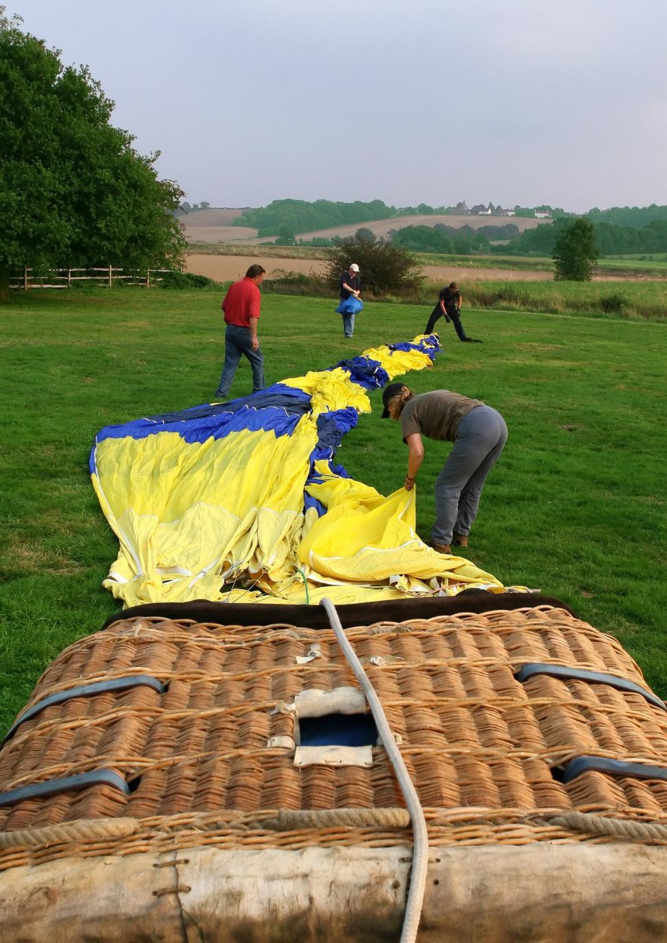 Free Image of Group of People Working on a Kite in a Field 