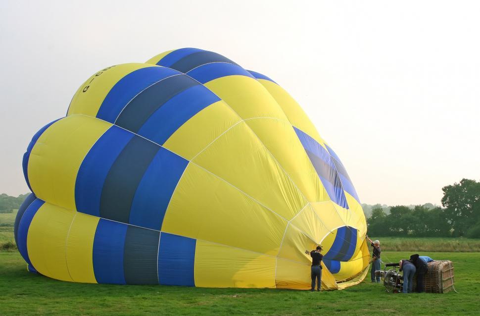 Free Image of Large Yellow and Blue Balloon on Lush Green Field 