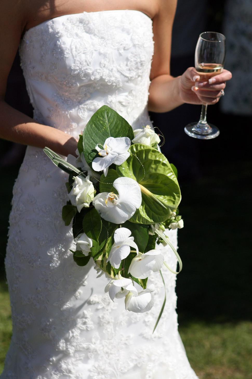 Free Image of Woman in Wedding Dress Holding Glass of Wine 