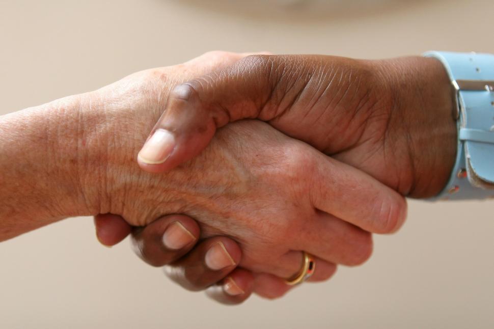Free Image of Two People Shaking Hands Over a Table 