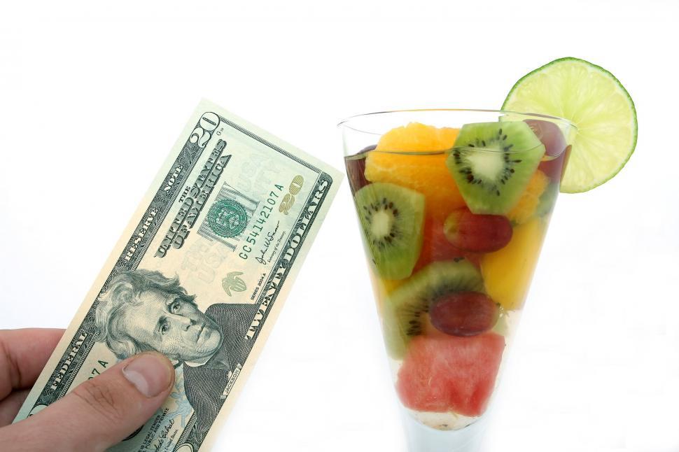 Free Image of Person Holding Money Bill and Glass of Fruit Salad 