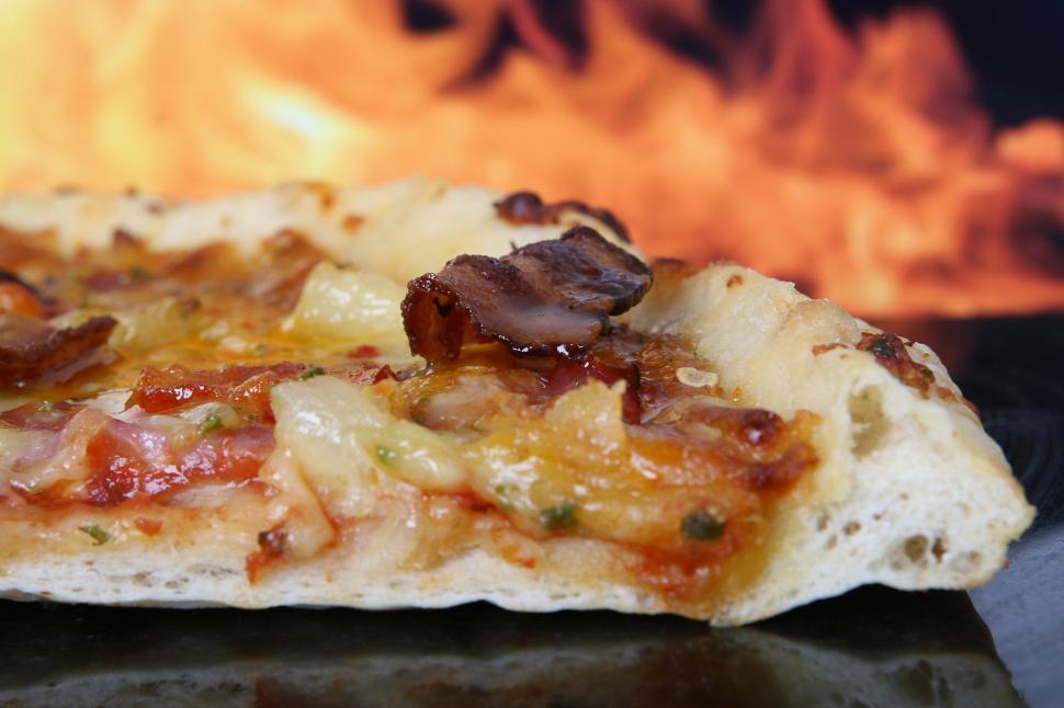 Free Image of Pizza Heating Near Fire on Kitchen Counter 
