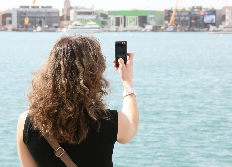 Free Image of Woman Capturing Picture of Water Body 