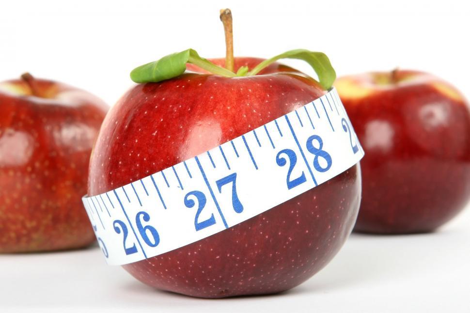 Free Image of Three Apples Wrapped in Measuring Tape 