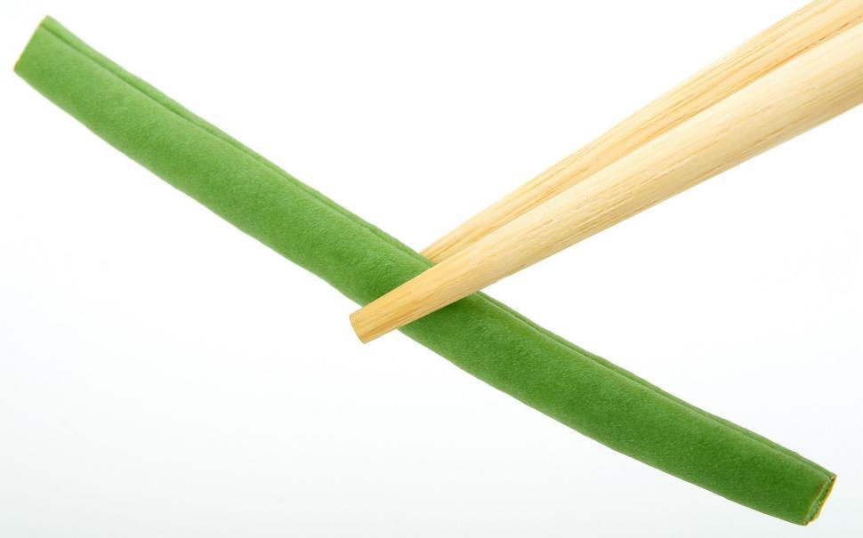 Free Image of Wooden Chopsticks Sticking Out of Green Paper 