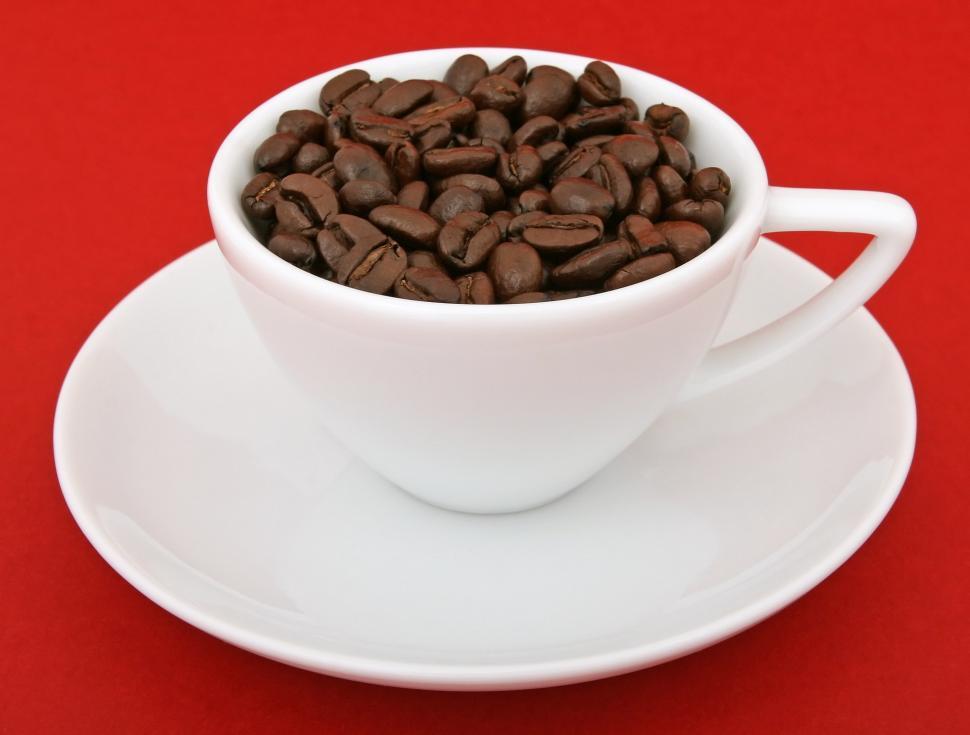 Free Image of A White Cup Filled With Coffee Beans on Top of a Saucer 