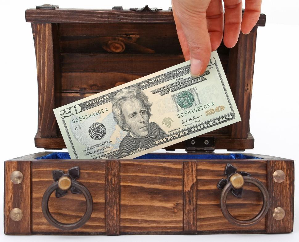 Free Image of Person Putting Money Into Wooden Chest 