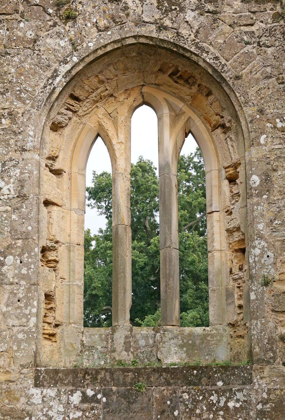 Free Image of Stone Building Window With Background Tree 