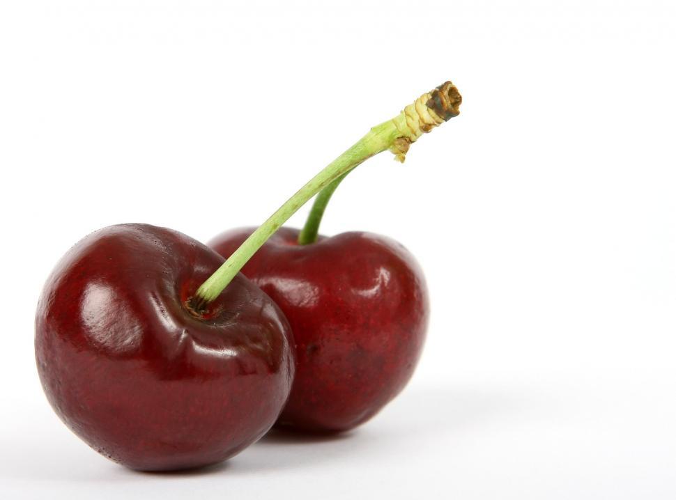 Free Image of Two Cherries Sitting on Top of Each Other 