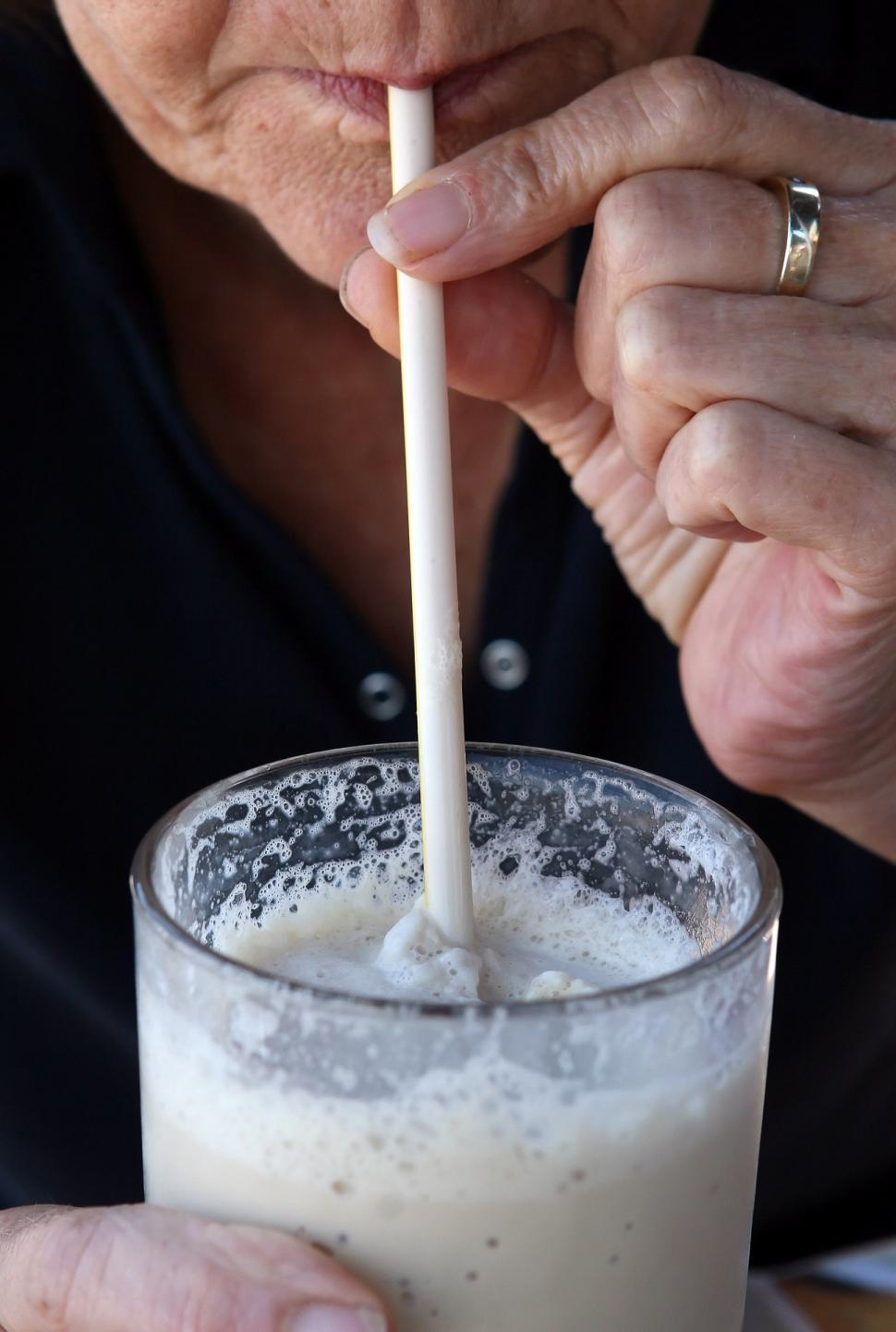 Free Image of Man Holding Straw in Glass of Milk 