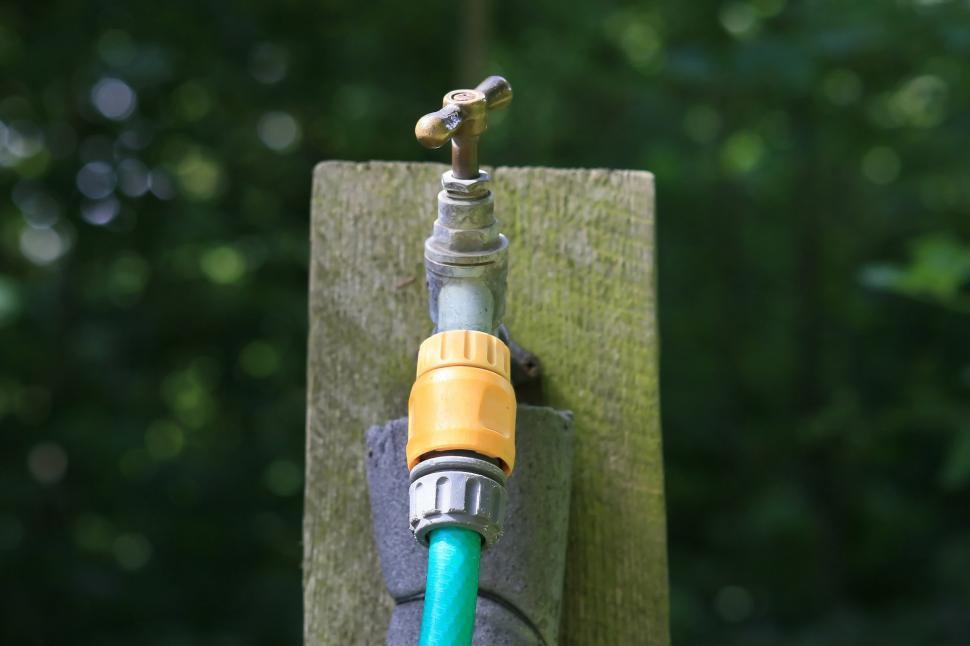 Free Image of Water Faucet Attached to Wooden Post 