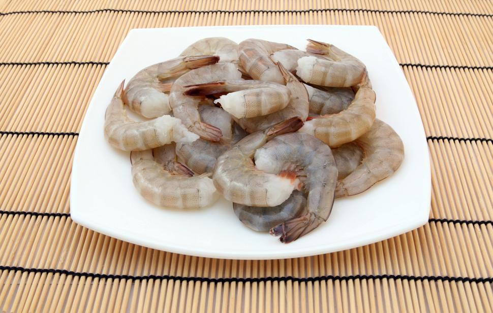 Free Image of White Plate Filled With Shrimp on Bamboo Mat 