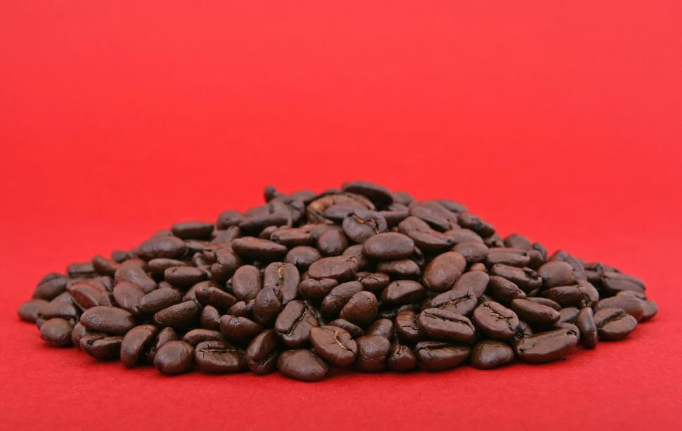 Free Image of A Pile of Coffee Beans on a Red Background 