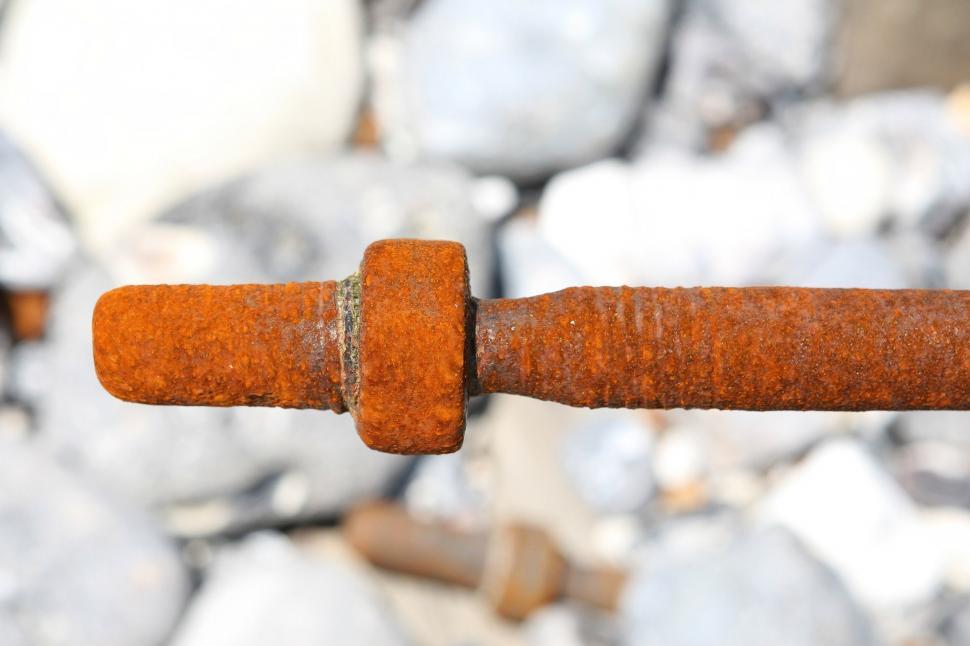 Free Image of Rusted Metal Barbwire With Rocks in Background 