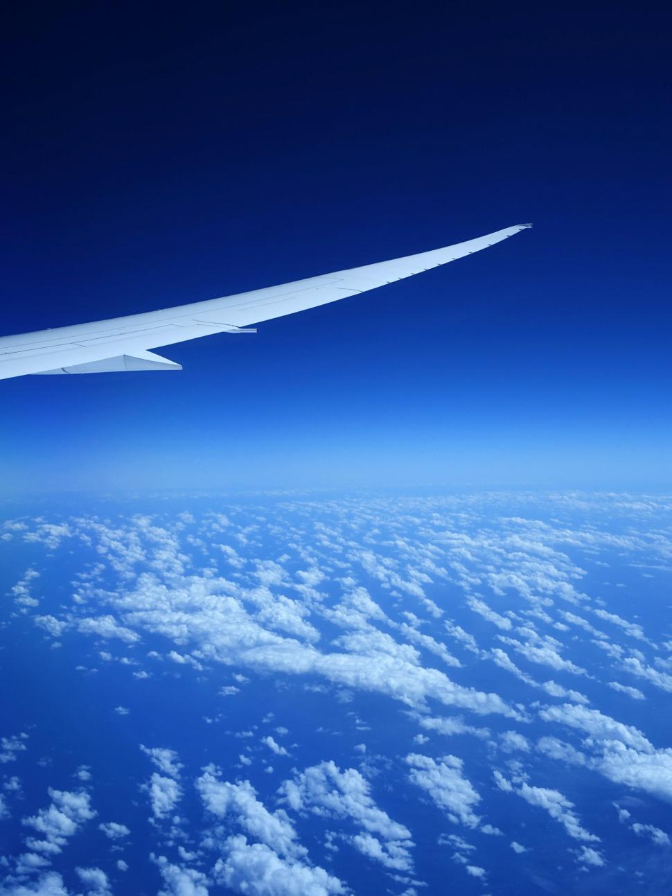 Free Image of Airplane Wing Flying Above Clouds 