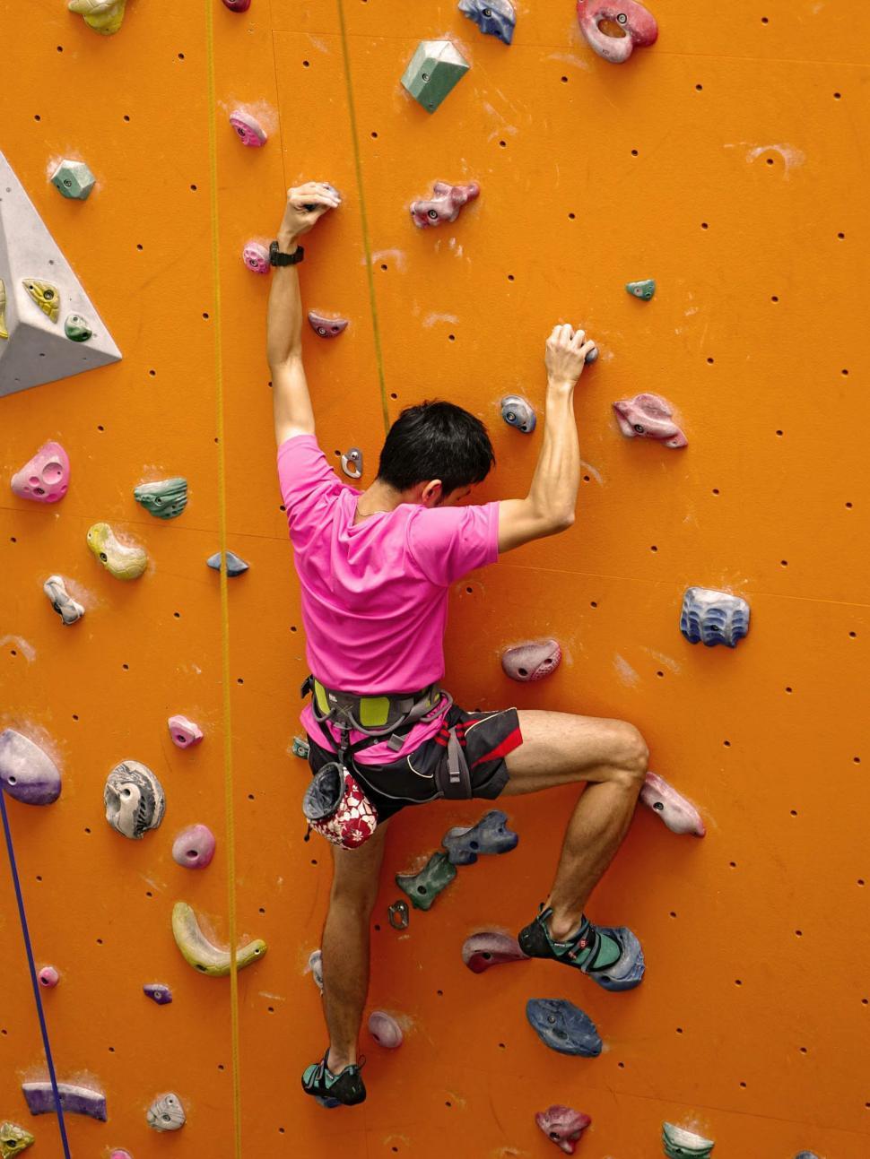 Free Image of Man Climbing Rock Wall With Raised Hands 