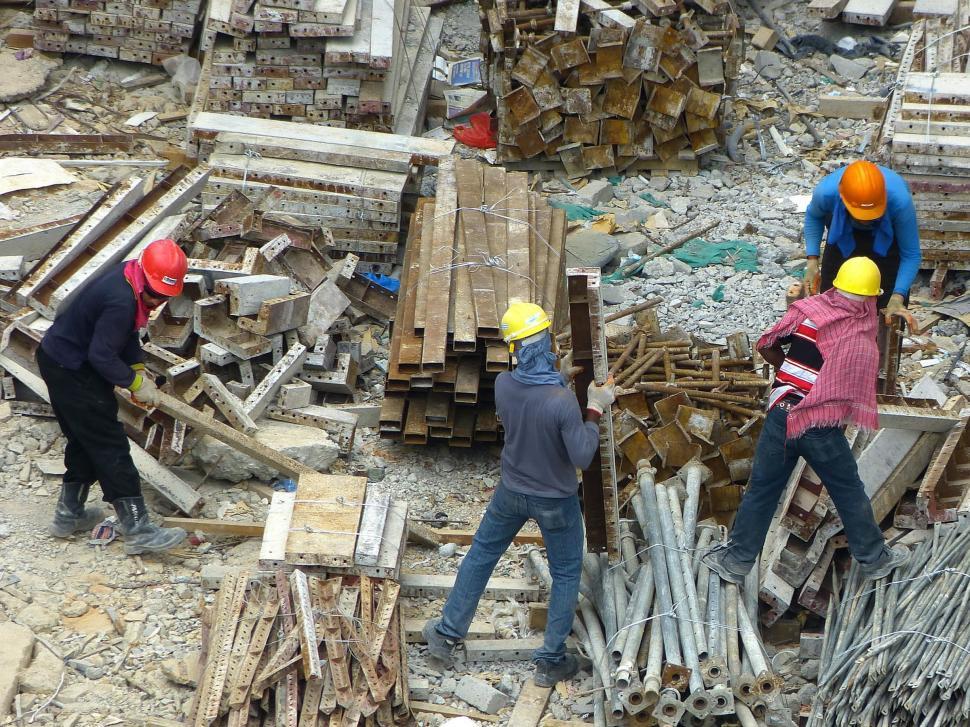 Free Image of Group of People Standing Around Pile of Rubble 