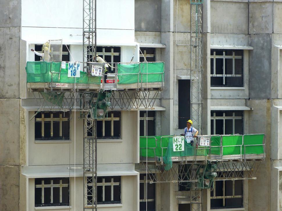 Free Image of Man Working on a Buildings Scaffolding System 