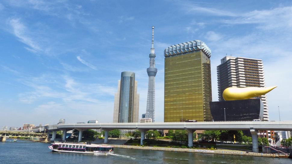 Free Image of Boat Traveling Down River Next to Tall Buildings 