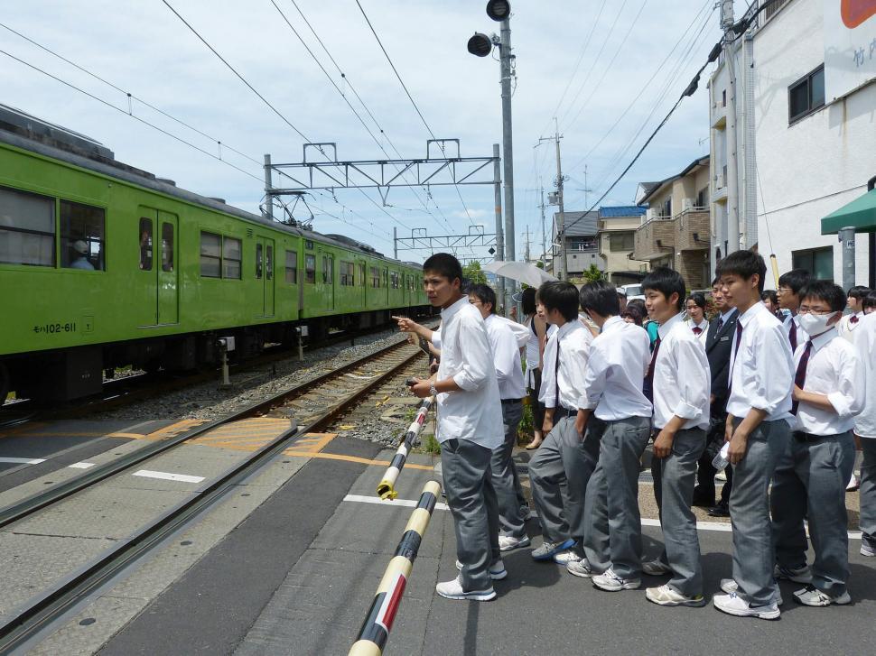 Free Image of Group of People Standing in Front of a Green Train 