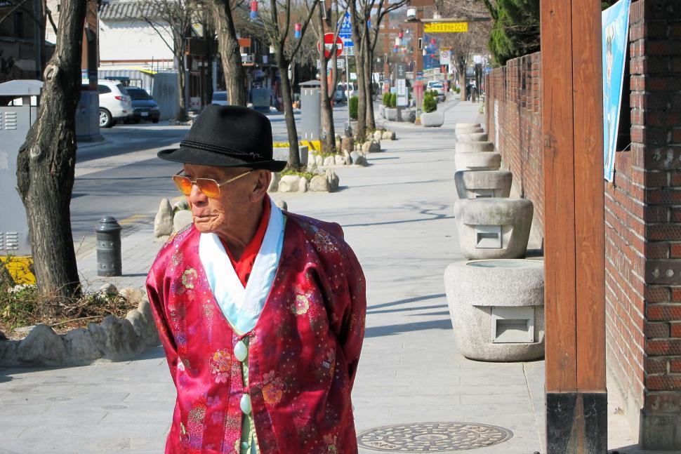Free Image of Man in Red Kimono Walking Down Sidewalk 