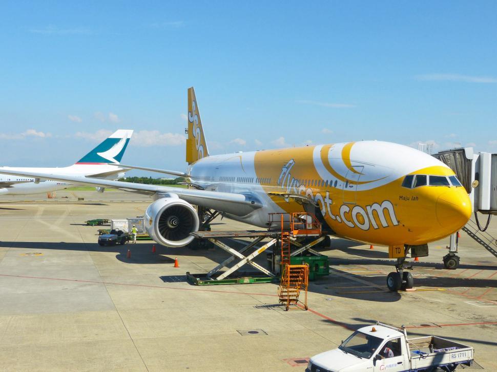 Free Image of Yellow and White Airplane Parked on Tarmac 