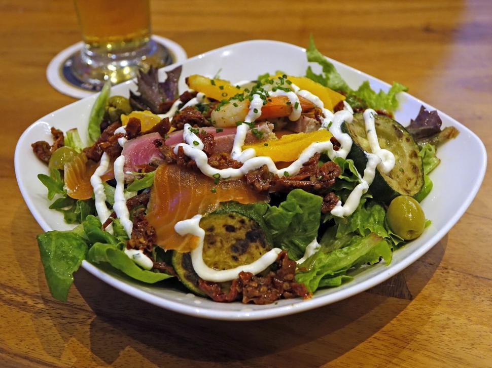 Free Image of White Bowl Filled With Salad and Glass of Beer 