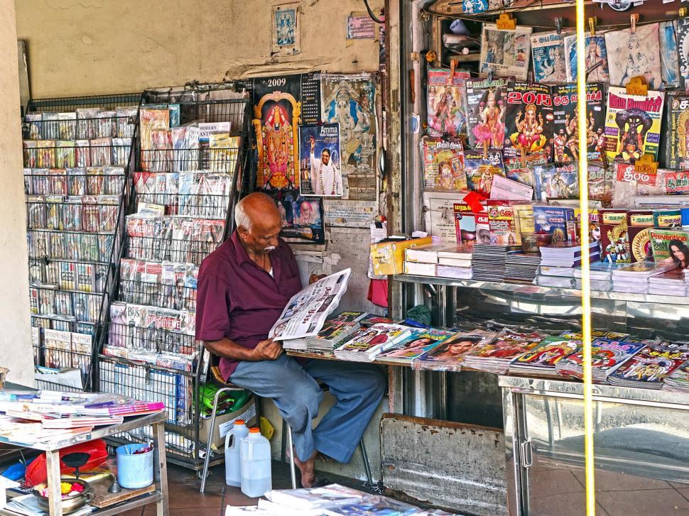 Free Image of Man Reading Newspaper Outside Store 
