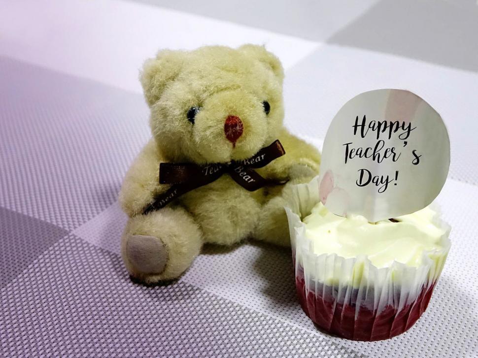 Free Image of Teddy Bear Sitting Next to Cupcake 