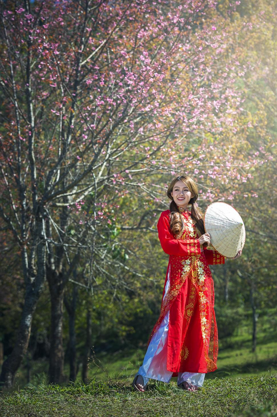 Free Image of Woman in Red Dress Holding White Ball 