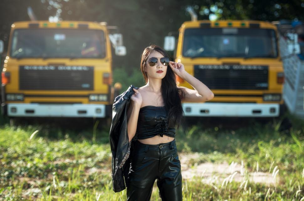 Free Image of Woman Standing in Field Next to Yellow Truck 
