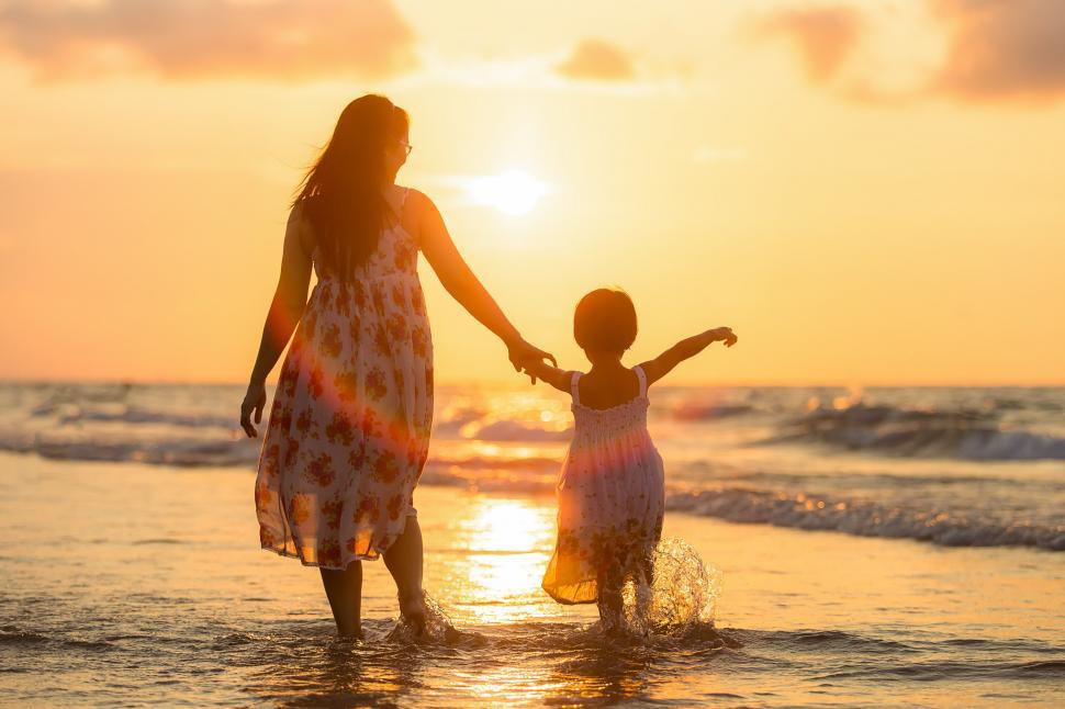 Free Image of Woman and Child Standing in Water at Beach 
