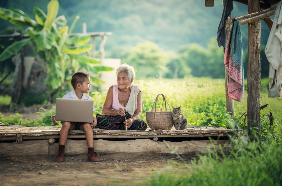 Free Image of Woman and Boy Sitting on Bench With Laptop 