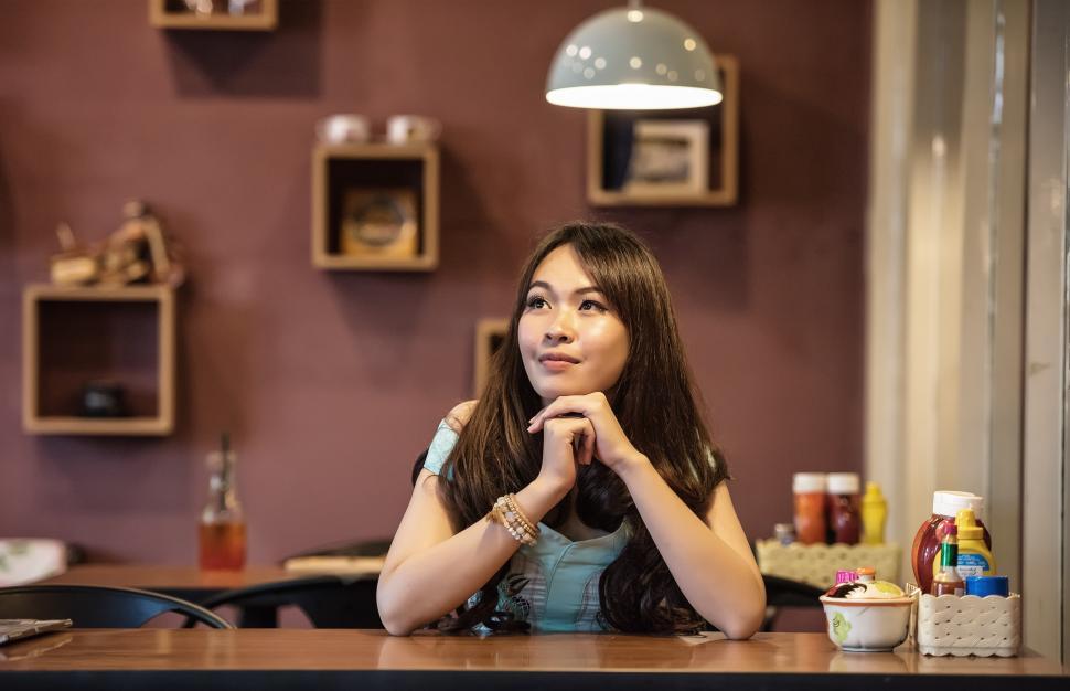 Free Image of Woman Sitting at Table in Restaurant 