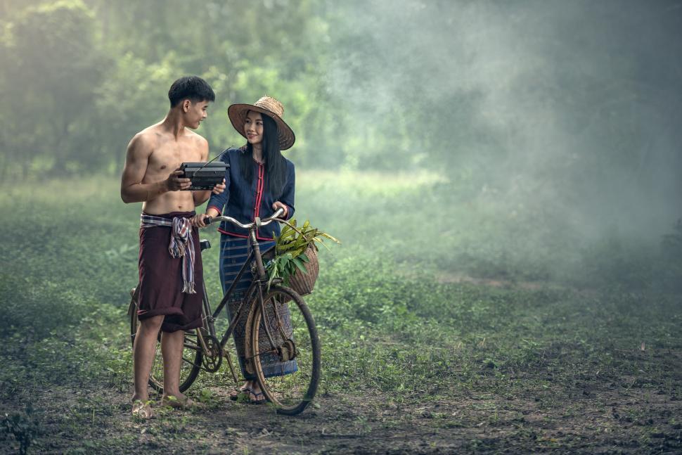 Free Image of Man and Woman Standing Next to a Bike 