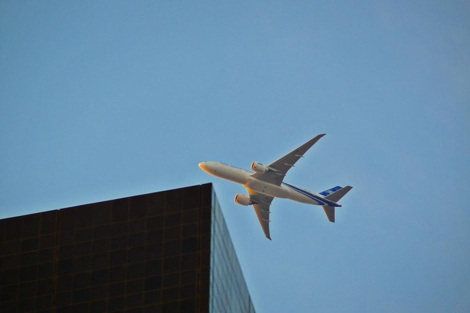 Free Image of Large Jetliner Flying Through a Blue Sky 