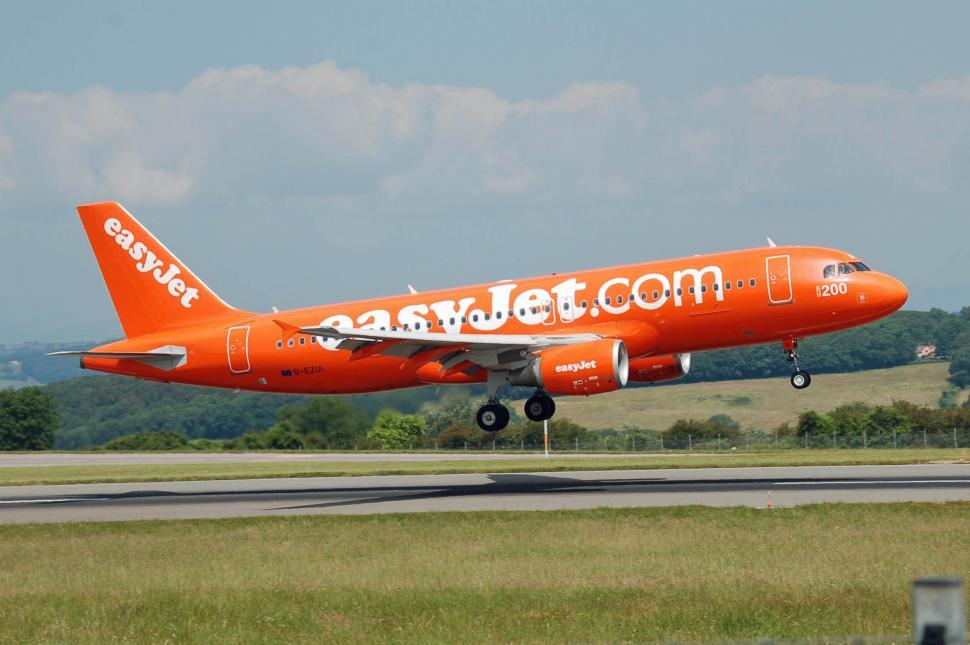 Free Image of Large Orange Jetliner Taking Off From Airport Runway 