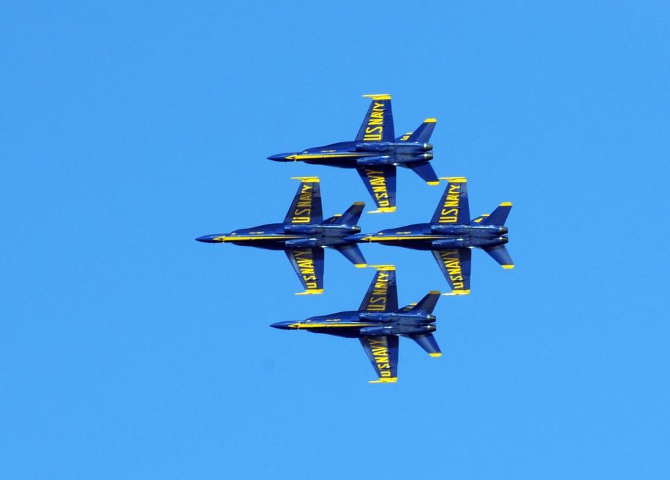 Free Image of Four Blue Fighter Jets Flying in Formation in a Blue Sky 