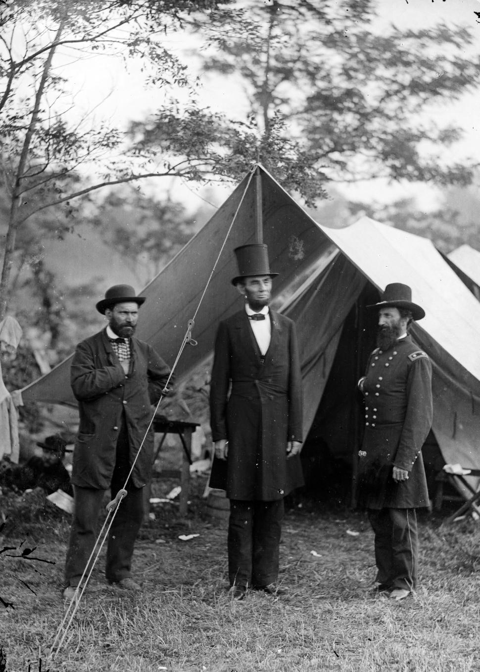 Free Image of Group of Men Standing in Front of a Tent 