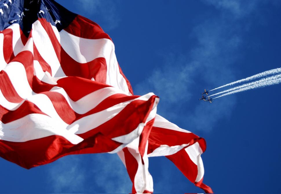 Free Image of American Flag Flying With Plane in Background 