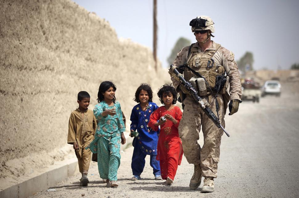 Free Image of Soldier Walking Down Street With Children 