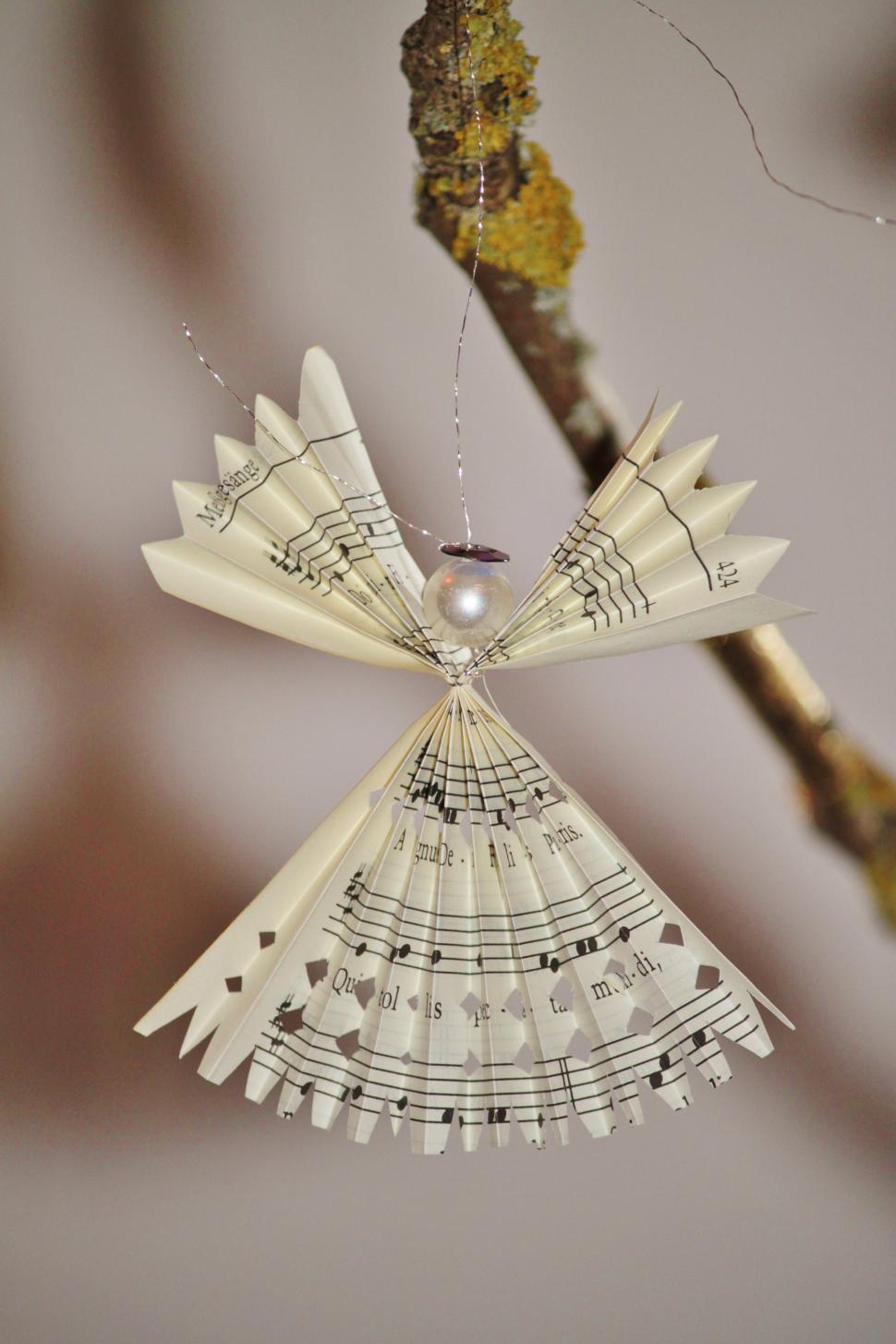 Free Image of Paper Angel Ornament Hanging From Tree Branch 