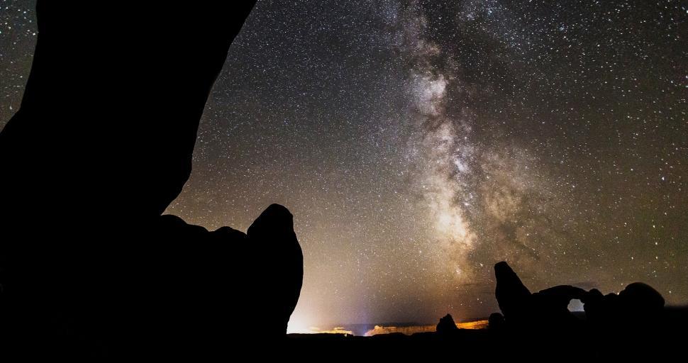 Free Image of Person Sitting on a Rock Looking at the Stars 