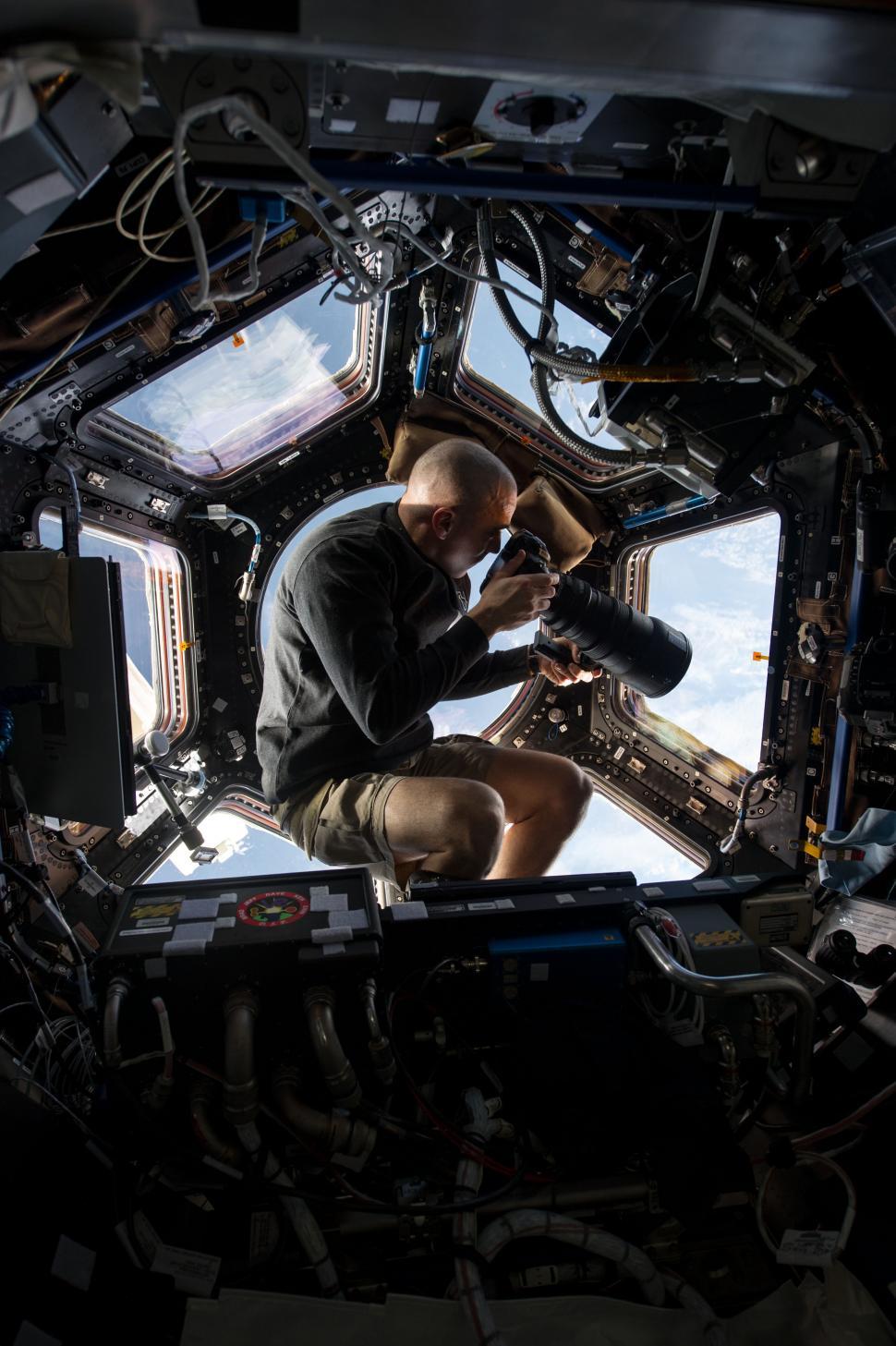 Free Image of Man Observing Space Through Window in Station 